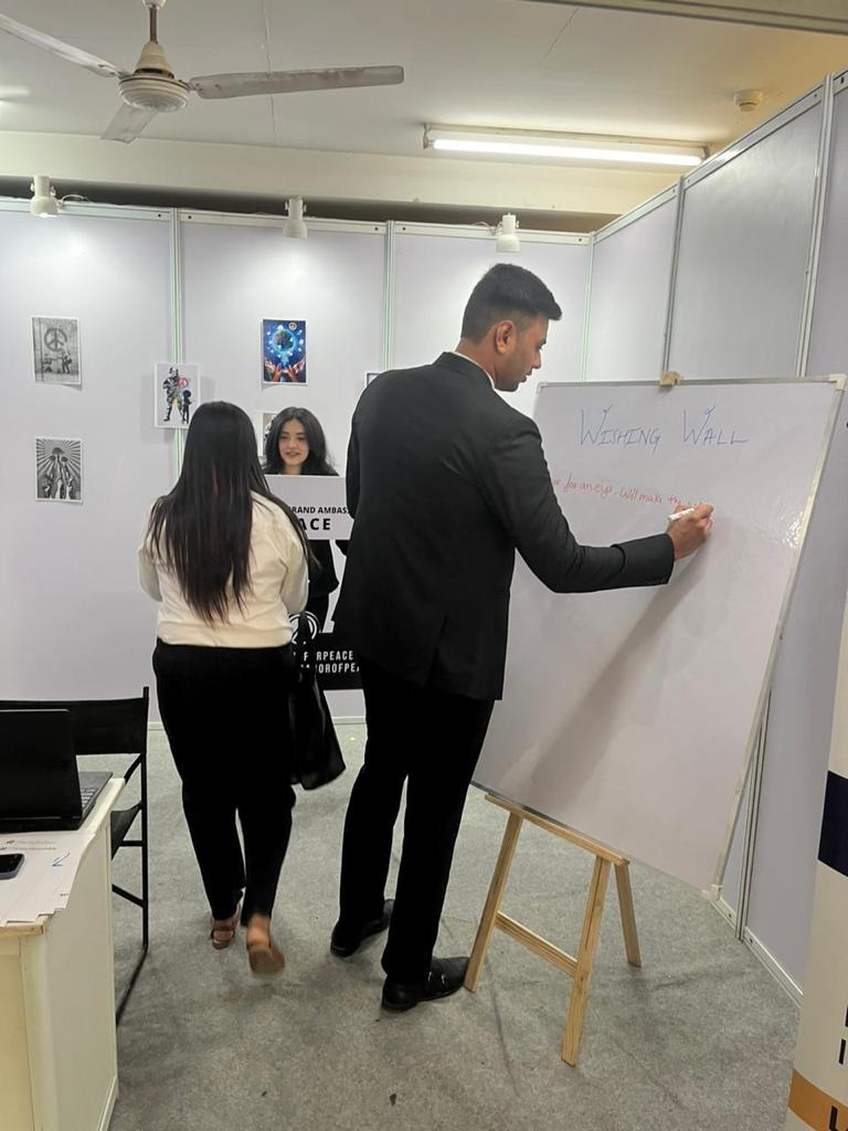 A man and woman standing in front of a whiteboard, discussing a project during a business meeting.