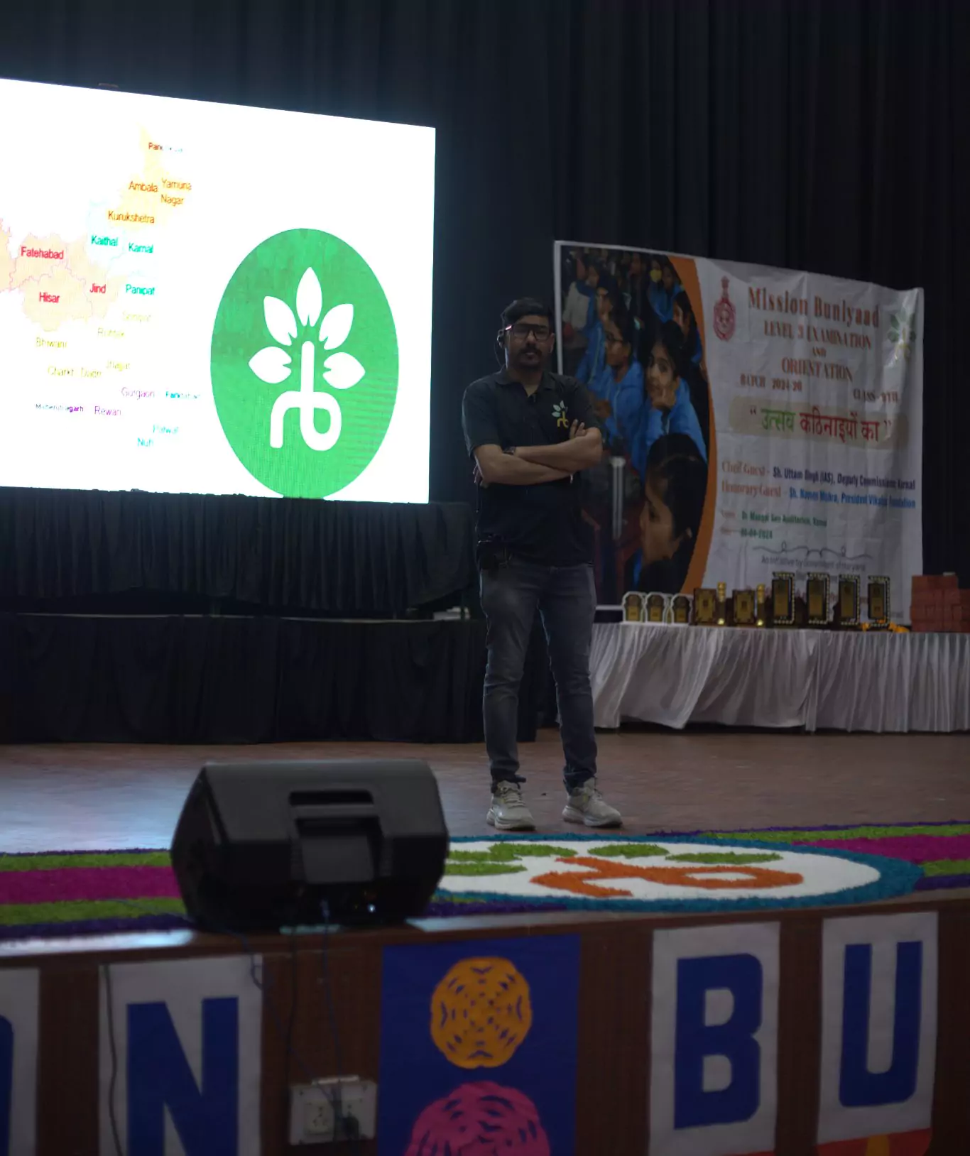 A man standing on a stage interacting with the audience.