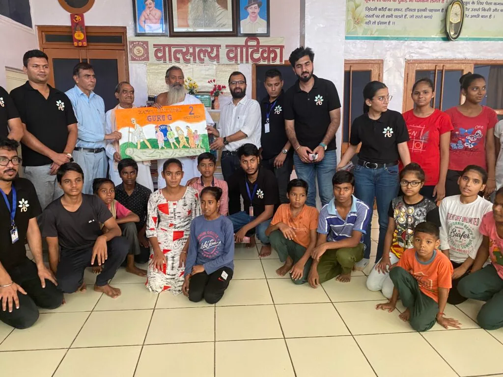 A group of people smiling and posing for a picture while holding an Indian flag.