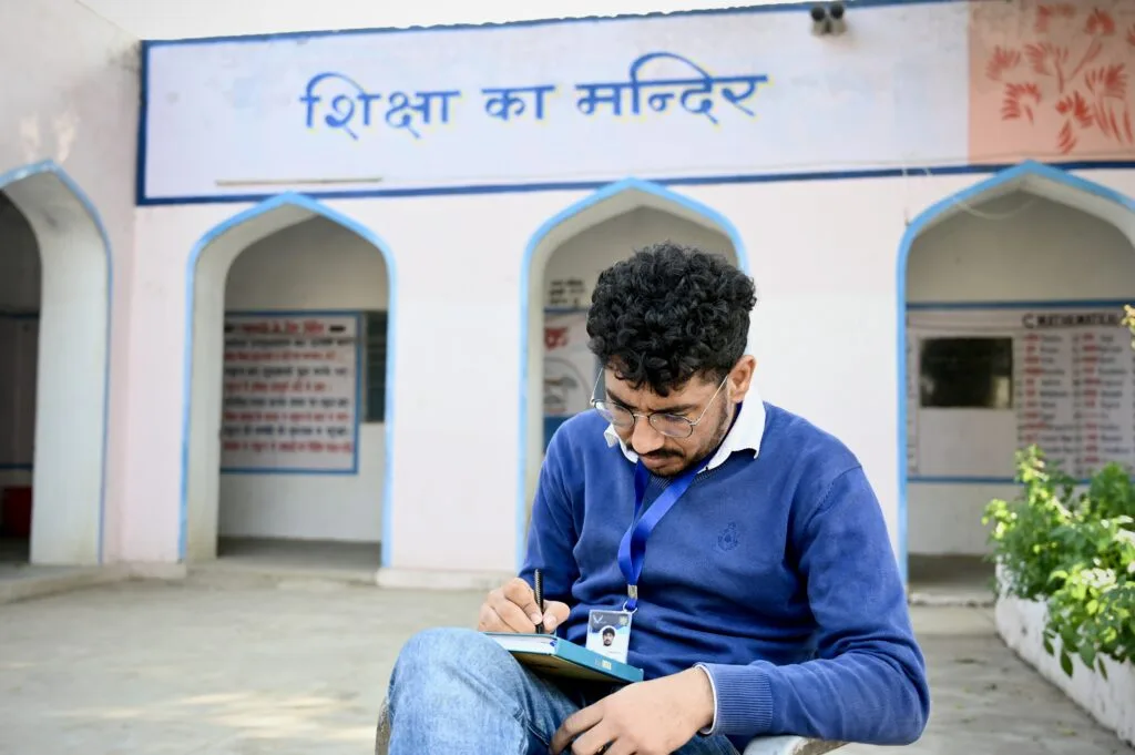 A man sitting on a chair in front of a building.