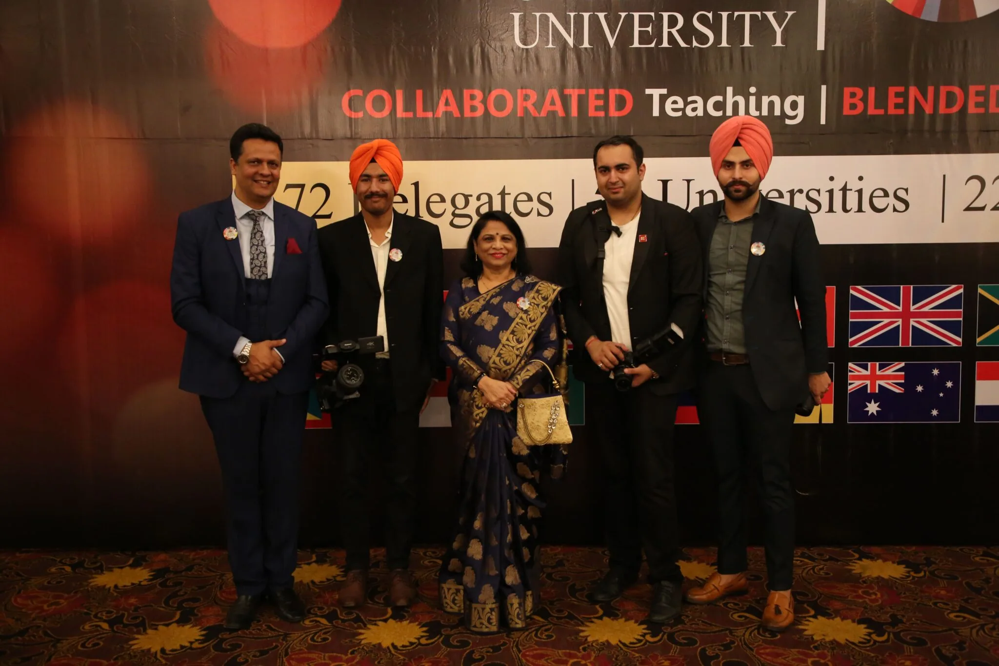 A diverse group of individuals standing in front of a banner at an event.