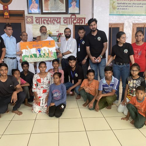 A group of people smiling and posing for a picture while holding an Indian flag.