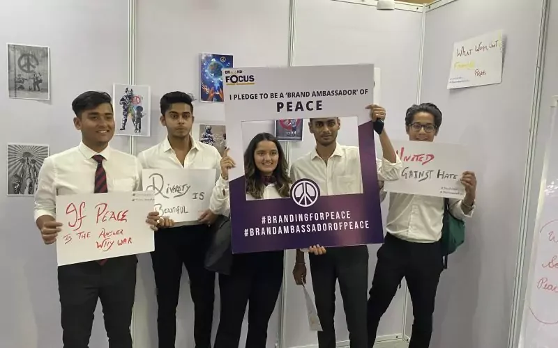 People standing in front of a wall holding banners.